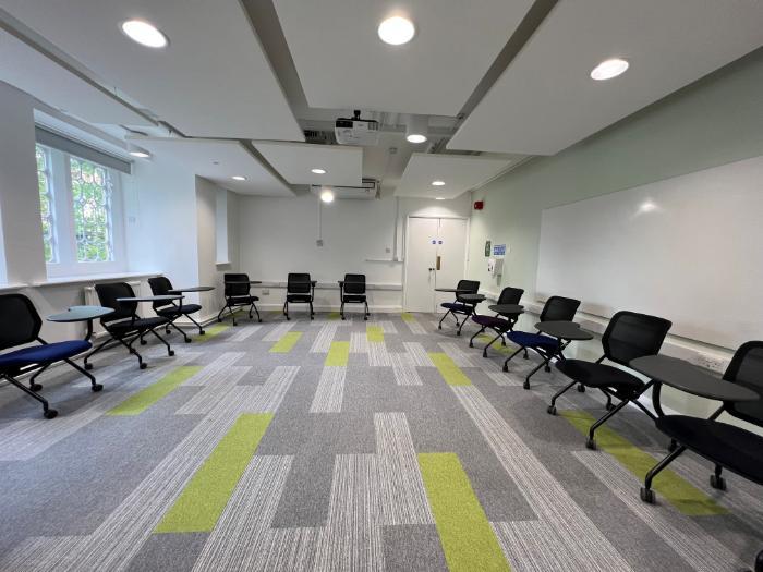 Flat floored teaching room with tablet chairs in horseshoe set-up.