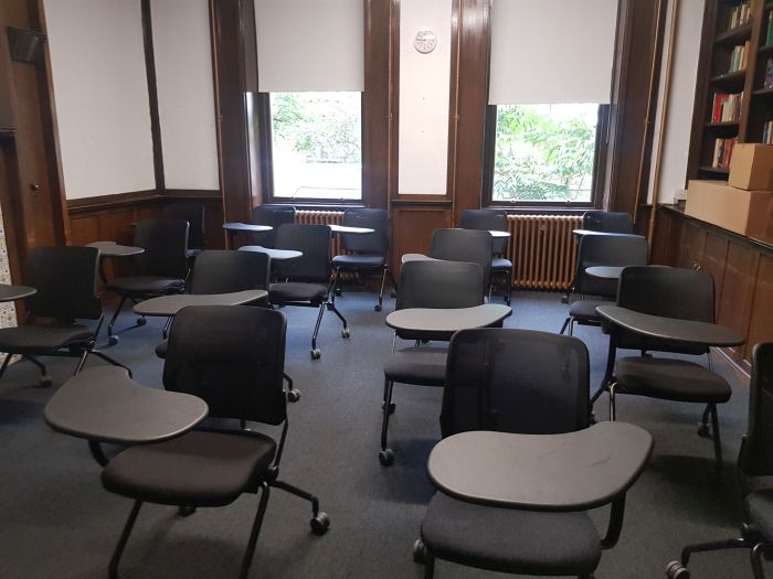 Flat floored teaching room with rows of tables and chairs