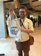 Photo of Phil Nicholson holding tote bag created at TEDx