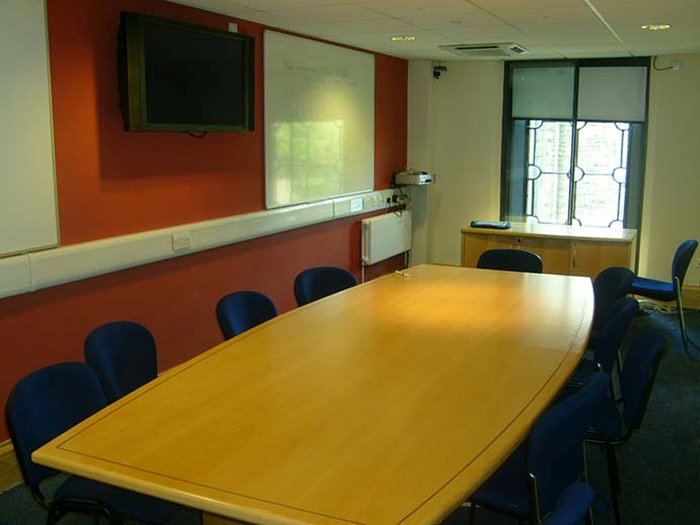 Flat floored meeting room with boardroom table and chairs and video monitor