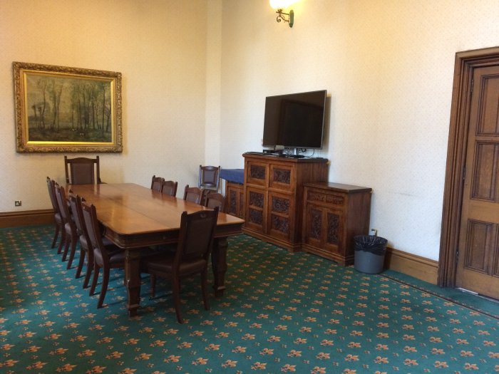 Flat floored meeting room with boardroom table and chairs and video monitor