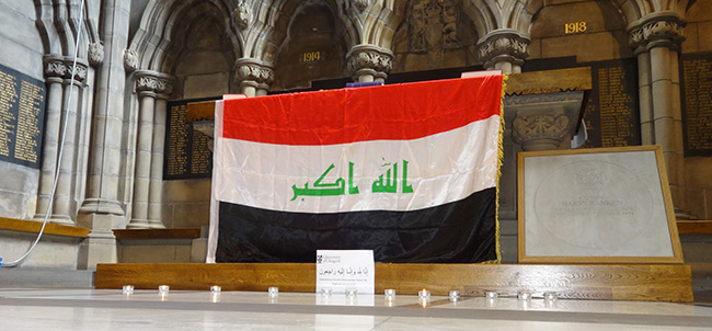 Image of the University Chapel, including the Great War Roll of Honour, with an Iraqi flag draped over the altar.