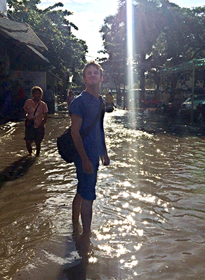 Fergus Taylor standing in flooded street in Cambodia