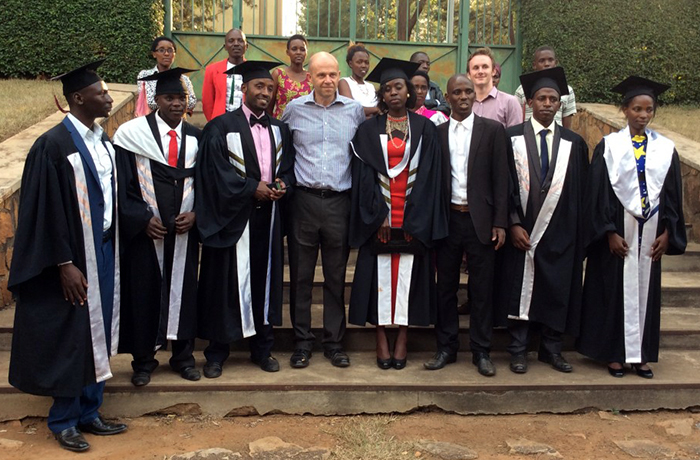 Fergus Taylor with a gowned group of graduates from the College of Medical and Health Sciences, University of Rwanda