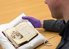 Dr Matthew Creasy holding the University's first edition of A Christmas Carol 