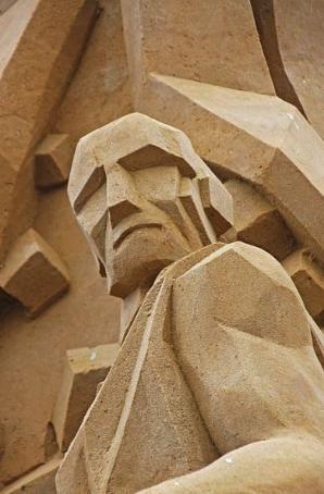 photograph of a cubist sculpture in sandstone of the shoulders and  head of a man with very sharp features