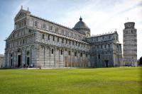 photograph of the white marble medieval cathedral in Pisa, with the leaning tower in the right-side background