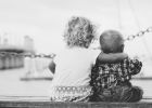 Image of two babies hugging on a bridge