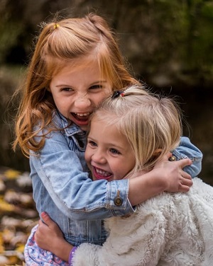 Image of two young girls hugging happily