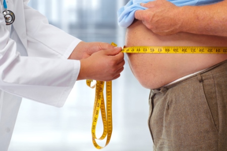 Photo of obese man having his waist measured