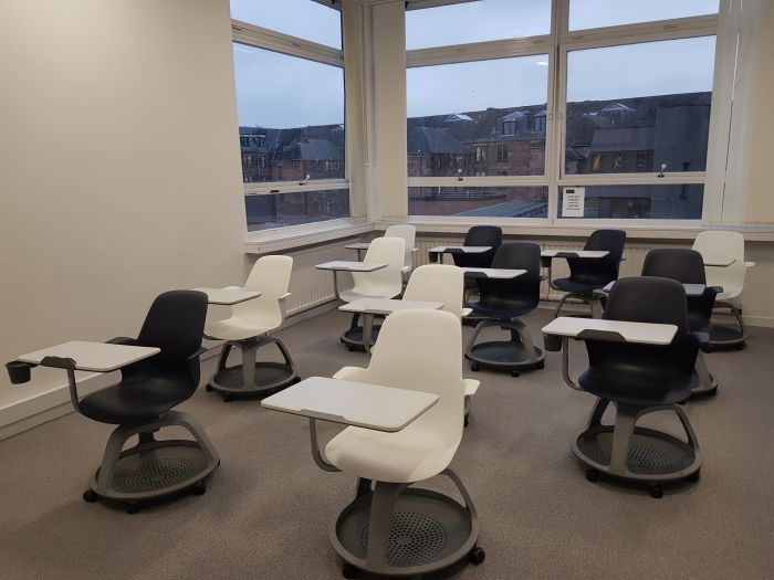 Flat floored teaching room with tablet chairs.