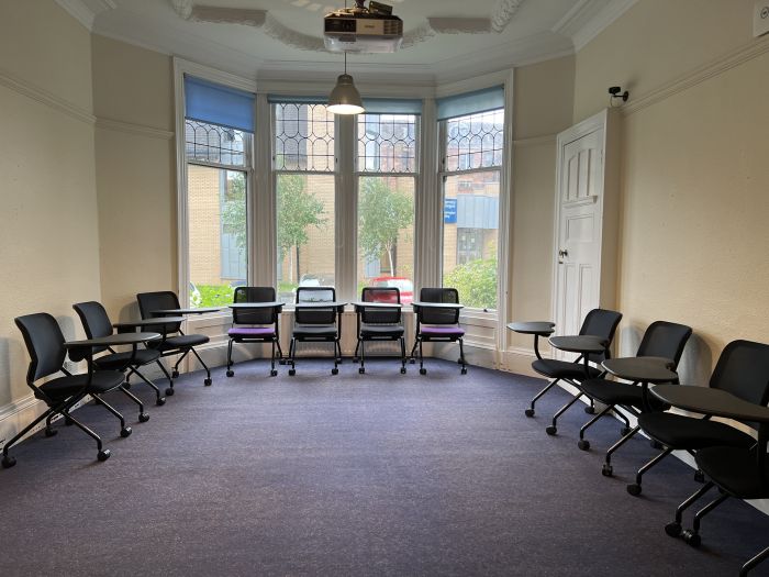 Flat floored teaching room with rows of tablets chairs