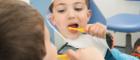 Child cleaning teeth in a mirror