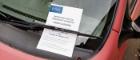 Image of a parking notification leaflet stuck under a windscreen wiper