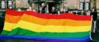 Image of UofG people holding the LGBT+ flag