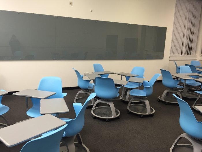 Flat floored teaching room with tablet chairs and glassboard