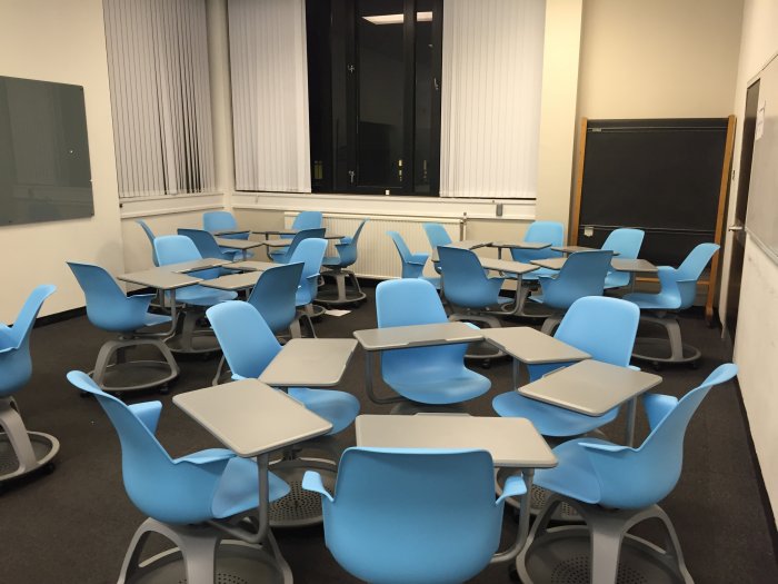 Flat floored teaching room with tablet chairs, glassboard