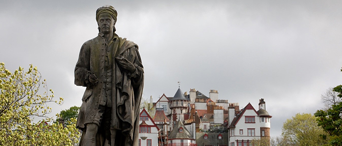 Image of a statue of Allan Ramsay with Ramsay Garden in the background
