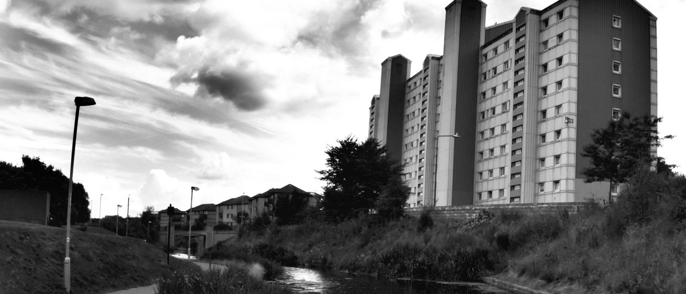 Black and white image of housing by a river
