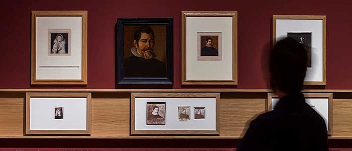 A photograph of someone looking at images at the Copied by the Sun exhibition, held at the Museo Nacional del Prado, 18 May – 4 September 2016 