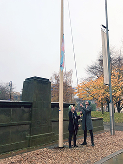 Image of the trans flag being raised to mark the 2017 transgender day of remembrance.