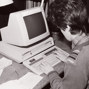 A woman uses a computer in the 1980s