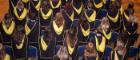 Students standing next to their seats in Bute Hall during graduation