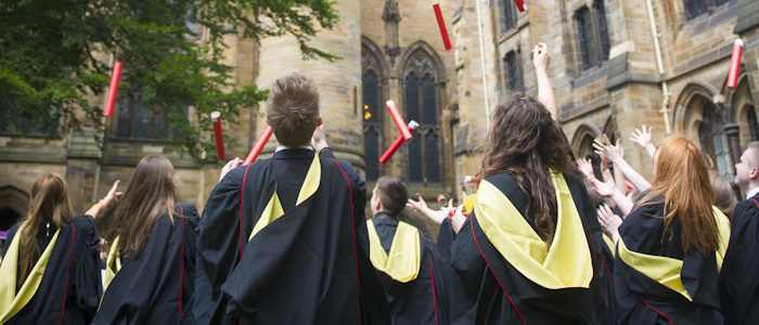 Students throwing their scrolls in the air during graduation