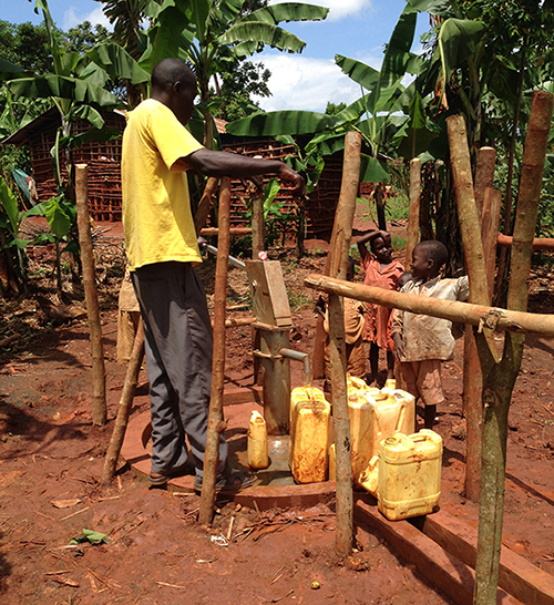 Villagers using a water pump in Uganda