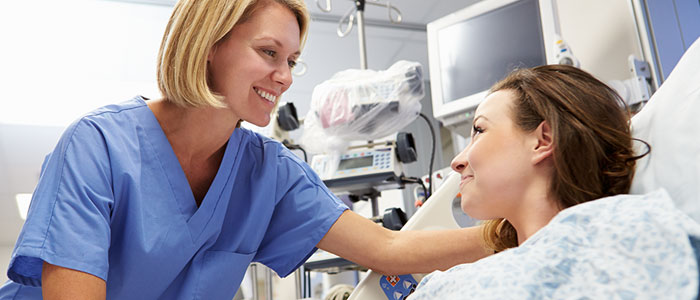 Image of nurse in ward at patient's bedside