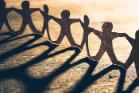 Human chain paper with light and shadow on wood table. 700 pixels