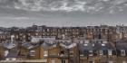 Rooftop view of old houses in London with grey sky and clouds. 1400 pixels