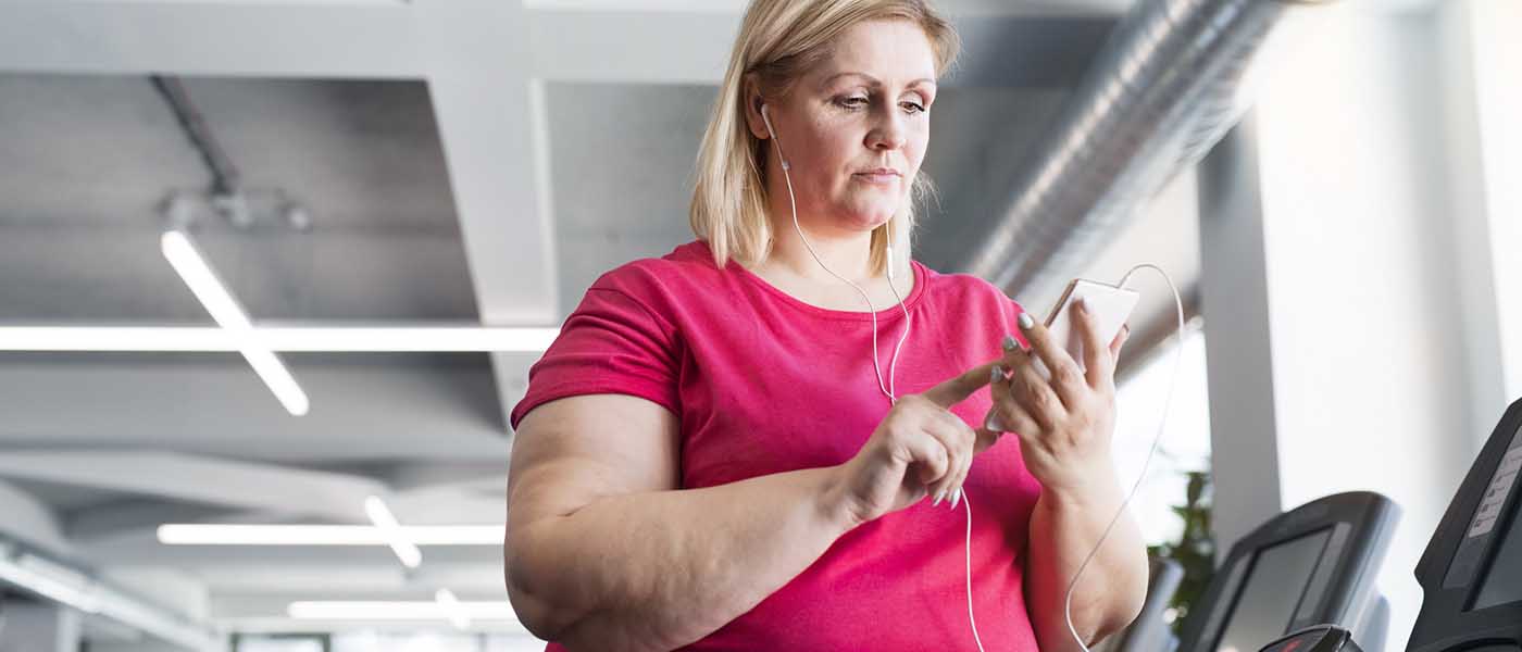 Woman in gym with Mobile Phone