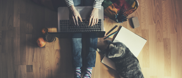 Photo of man working from home with cat and laptop