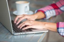 Photo of laptop, coffee cup and hands