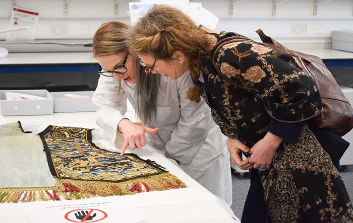 A Textile Conservation student showing their work