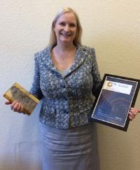 Photo of Professor Anna Cooper holding Athena SWAN Gold award