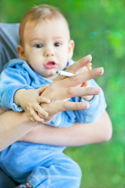 Baby being held while parent smokes, 483x724px