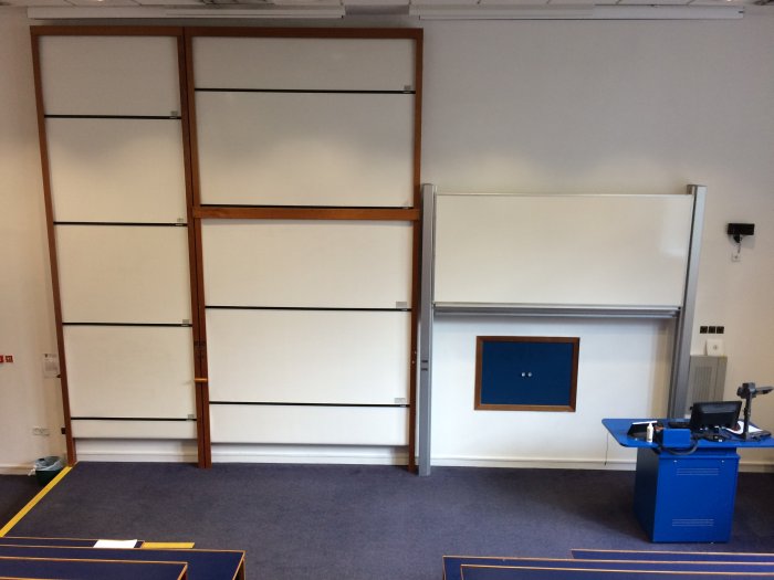 Raked lecture theatre with whiteboards, screens, visualiser, and PC
