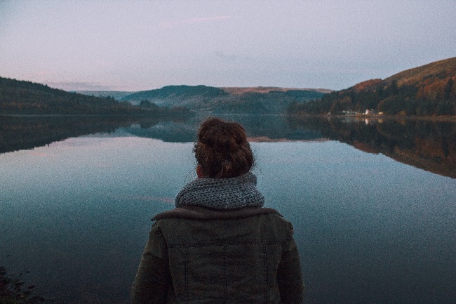 European study into institutional responses to domestic abuse involving SCCJR. Size 650. Woman reflecting over lake.