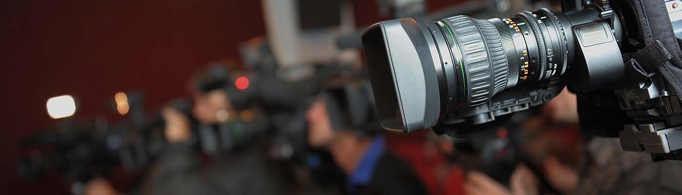 cameras and journalists at an indoor press conference