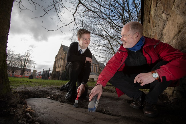 Mark McGettigan, aged 14, and Professor Stephen Driscoll of the University of Glasgow examine one . Photo Credit Martin Shieldsof the rediscovered stones at Govan Old Parish Church.