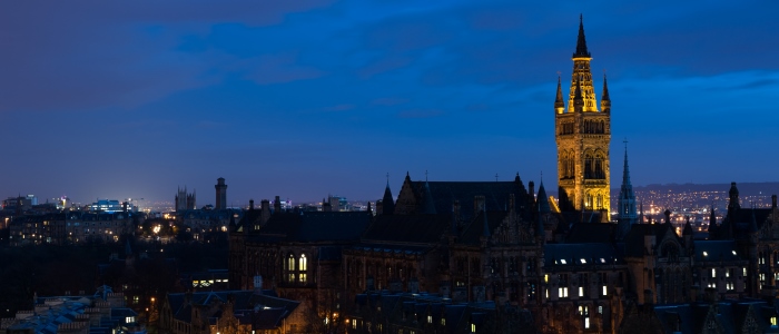 the main building in silhouette at night with tower lit up