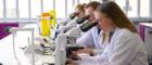 students looking through microscopes in a life sciences a lab