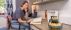 a femal student reading in her room