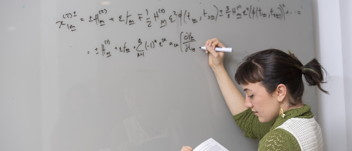 A student writing on the board during a maths and stats class