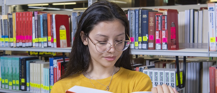 A student studying a language book in the library