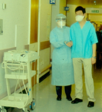 Brownlee unit nurse with patient, in masks and protective clothing - from Dr Kennedy