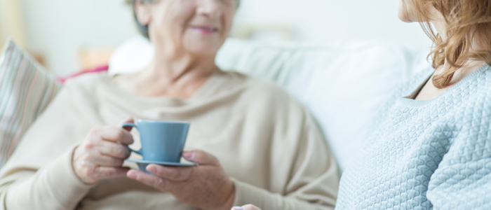 Photo of older woman and carer drinking tea