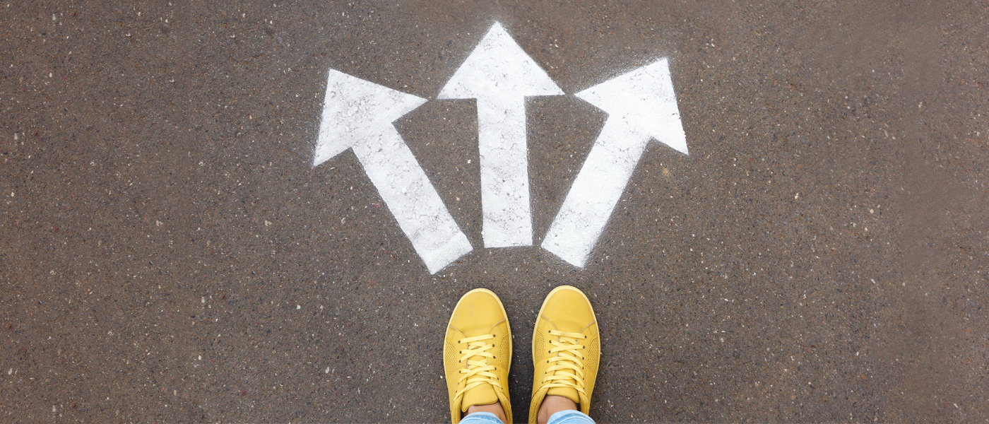 feet on a pavement with arrows pointing in three directions (photo: Shutterstock)